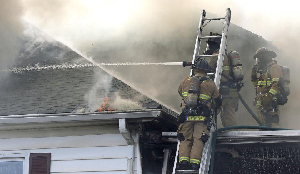 Firefighters work to battle a house fire Tuesday afternoon, Feb. 21, 2023, on West Virginia Avenue in Bessemer City.