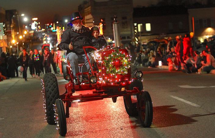 Dallas Bolton and his grandson Marko dela Cruz make their way down 16th Street on a 1947 Farmall during the Bedford Christmas parade Saturday. The pair won &quot;Best Tractor&quot; award in the parade.