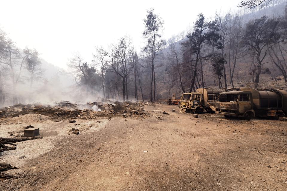 Burned vehicles are seen during a wildfire near Limni village on the island of Evia, about 160 kilometers (100 miles) north of Athens, Greece, Wednesday, Aug. 4, 2021. The European Union promised assistance Wednesday to Greece and other countries in southeast Europe grappling with huge wildfires after a blaze gutted or damaged more than 100 homes and businesses near Athens. (AP Photo/Thodoris Nikolaou)