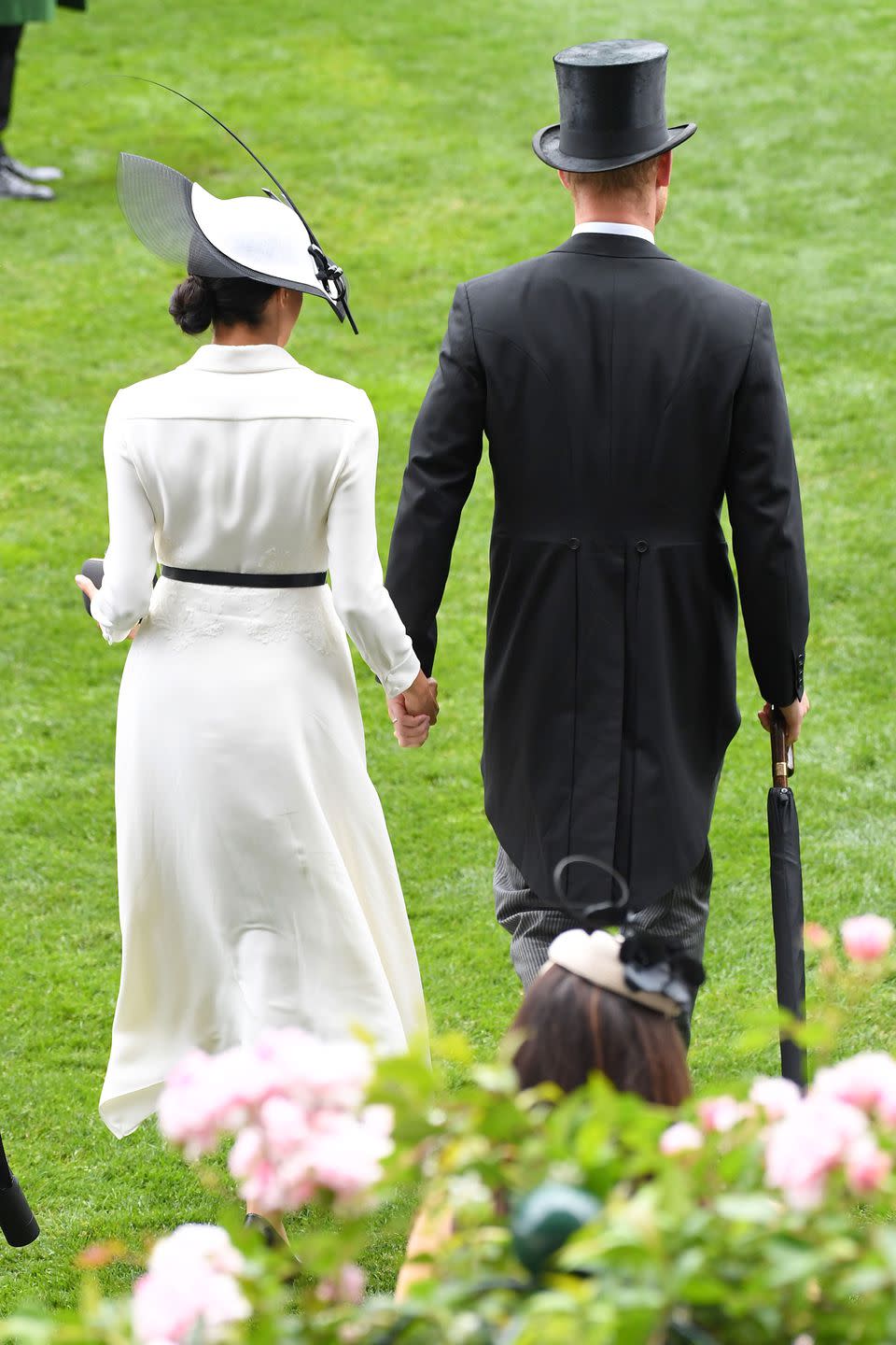 <p>The couple held hands as they crossed the racecourse.</p>