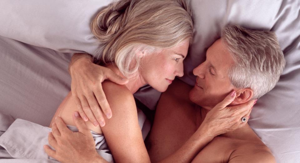 older man and woman in bed