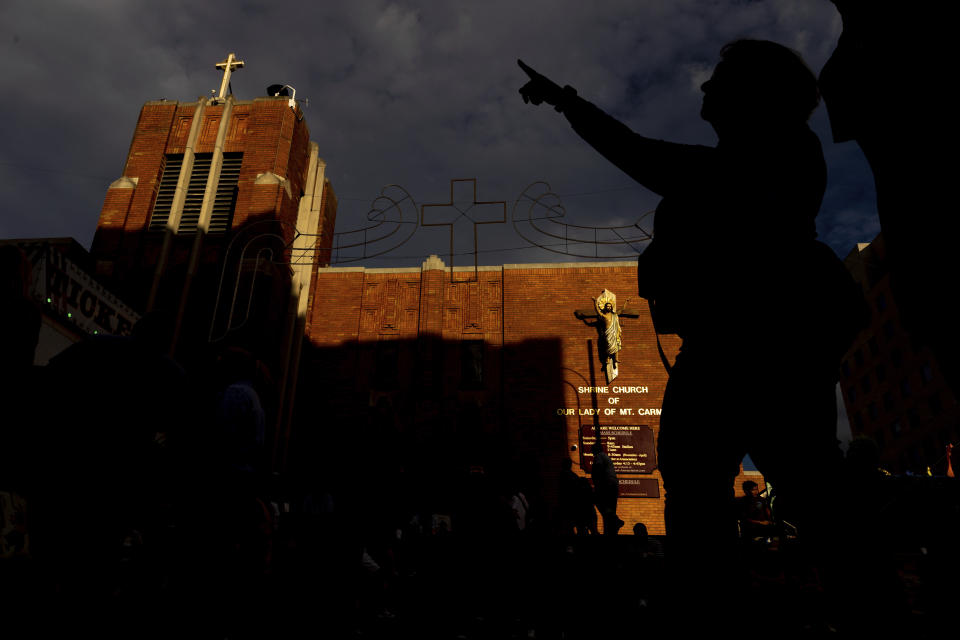 People walk past the Shrine Church of Our Lady of Mount Carmel, Wednesday, July 6, 2022, the first day of the Giglio feast in the Brooklyn borough of New York. (AP Photo/Julia Nikhinson)