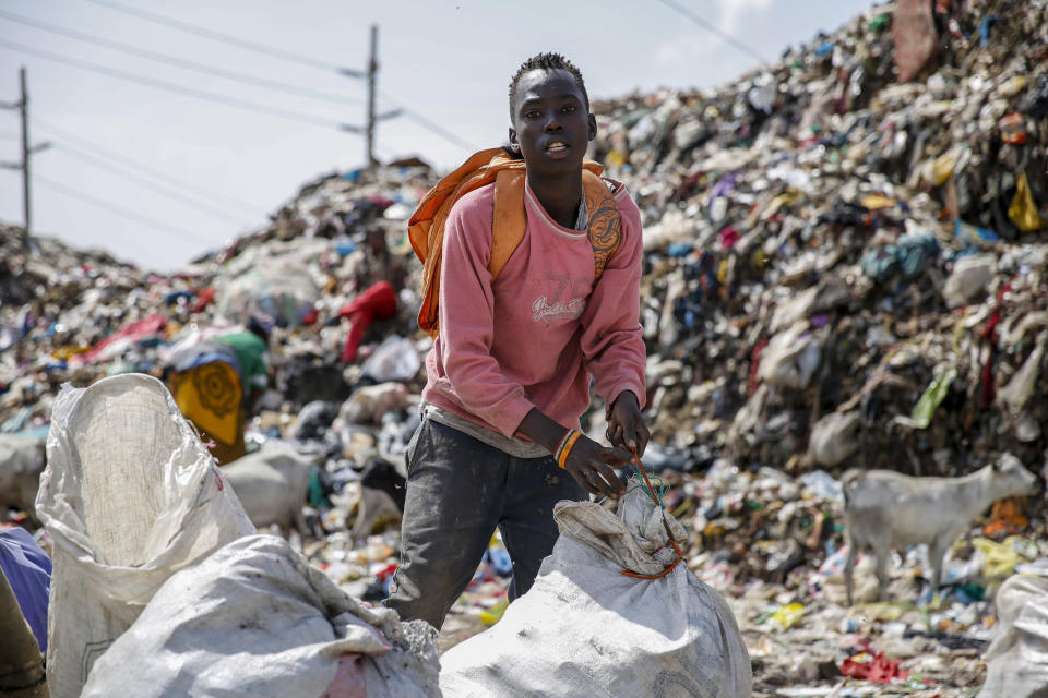 Mohamed Nassur, 17, scavenges for scrap metal to sell at Kenya's largest landfill Dandora where he now works after his mother lost her job and his school was closed due to the coronavirus pandemic, in Nairobi, Kenya Saturday, Sept. 26, 2020. The United Nations says the COVID-19 pandemic risks significantly reducing gains made in the fight against child labor, putting millions of children at risk of being forced into exploitative and hazardous jobs, and school closures could exacerbate the problem. (AP Photo/Brian Inganga)