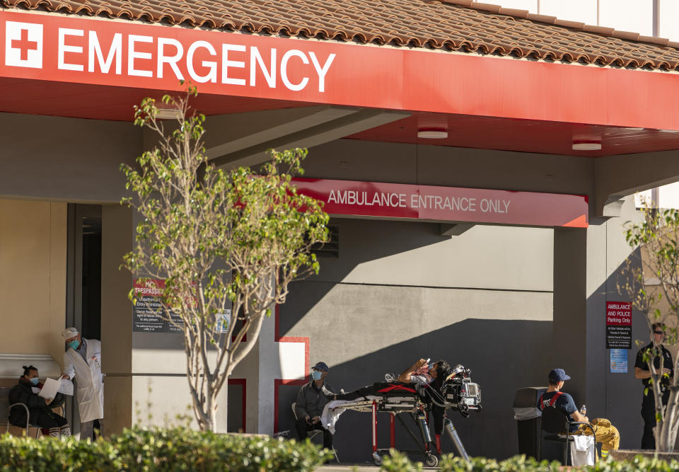 FILE - In this Dec. 18, 2020 file photo an unidentified patient receives oxygen on a stretcher, while Los Angeles Fire Department Paramedics monitor him outside the Emergency entrance, waiting for admission at the CHA Hollywood Presbyterian Medical Center in Los Angeles. California hospitals are facing increasingly difficult decisions about which services to postpone amid a crushing load of coronavirus patients. Intensive-care beds are full in Southern California and the Central Valley, with statewide availability at only 1.1%. (AP Photo/Damian Dovarganes,File)