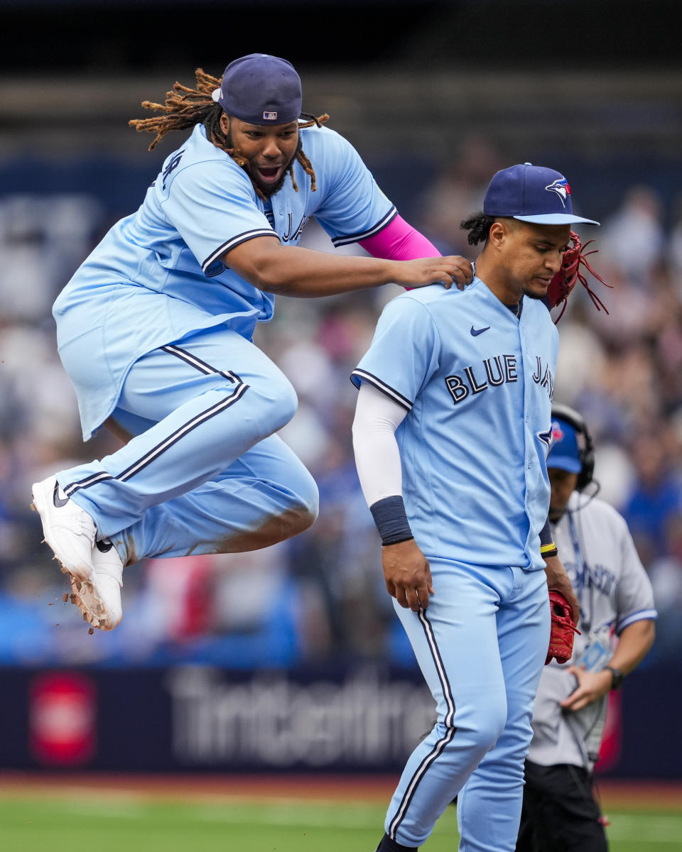 Toronto Blue Jays' Vladimir Guerrero Jr., left, leaps while celebrating with Santiago Espinal after the team's win over the Washington Nationals in a baseball game in Toronto on Wednesday, Aug. 30, 2023. (Andrew Lahodynskyj/The Canadian Press via AP)