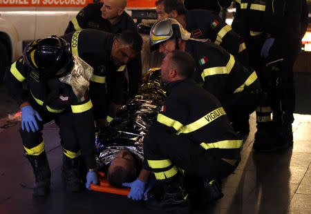 Fire fighters carry an injured person outside the underground where some of CSKA Moscow supporters were injured in Rome, Italy, October 23, 2018. REUTERS/Yara Nardi