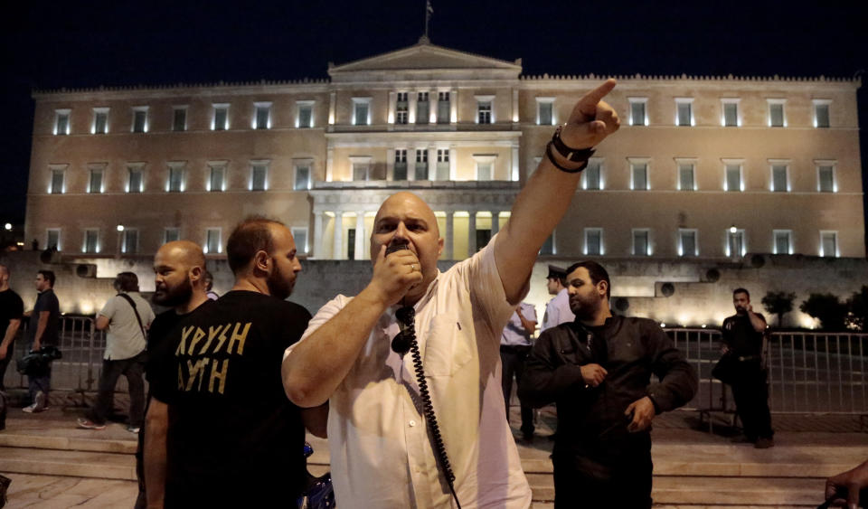 Ilias Panagiotaros, member of the Parliament of the extreme right party Golden Dawn gives orders to supporters in central Athens on Wednesday May 29, 2013, during a rally marking the anniversary of the fall of Constantinople to the Ottoman Empire in 1453. (AP Photo/Dimitri Messinis)