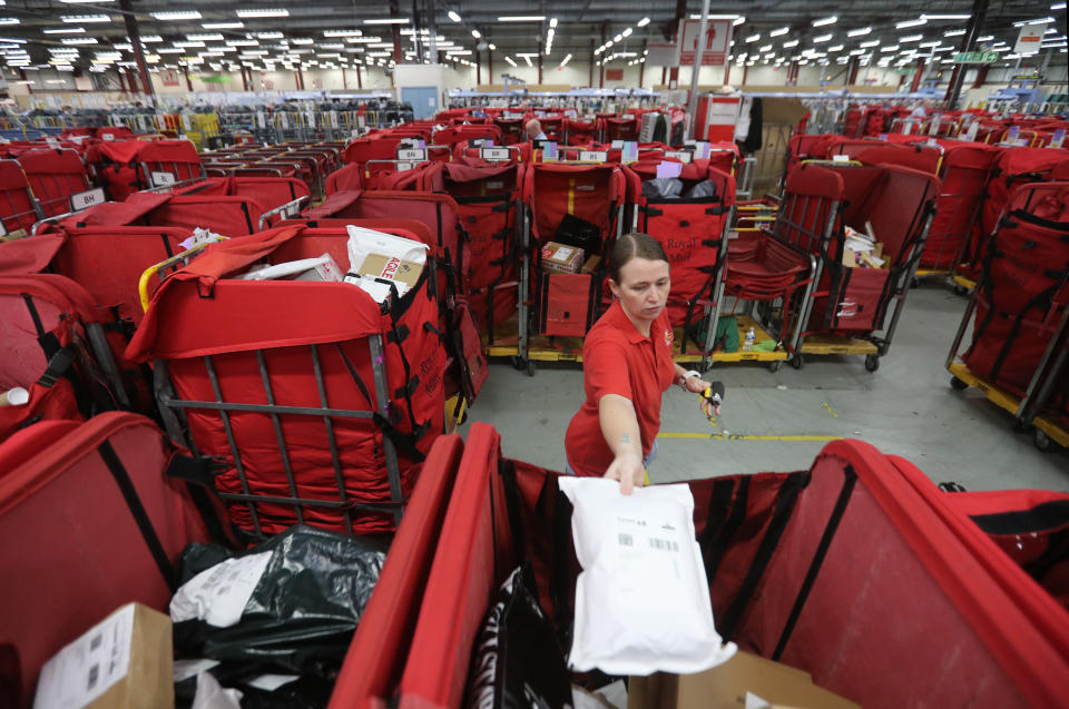 Royal Mail worker Lora McMillan sorts mail at the Royal Mail's Sorting Office in Turner Road, Glasgow, where postal workers are handling some of the millions of items of Christmas mail on what is expected to be one of their busiest day of the year.  (Photo by Andrew Milligan/PA Images via Getty Images)