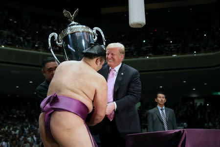 U.S. President Donald Trump presents the President’s Cup to wrestler Asanoyama, the winner of the Summer Grand Sumo Tournament at Ryogoku Kokigikan Sumo Hall in Tokyo, Japan May 26, 2019. REUTERS/Jonathan Ernst