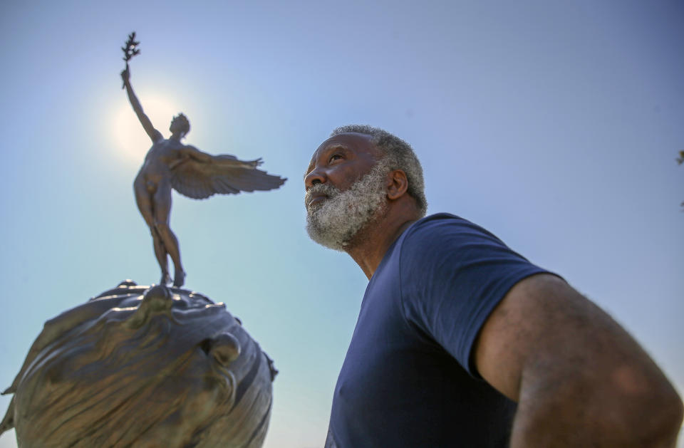 Reuben Green, a retired Black Naval officer, poses in front of the sculpture "Life," a memorial to those who lost their lives in World War I, at Memorial Park in Jacksonville, Fla., Friday, Feb. 26, 2021. (AP Photo/Gary McCullough)