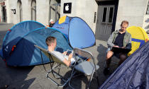 Customers from Belarus (front L and R) wait beside their tents outside an Apple store to buy the newly released Apple iPhone 7 in Berlin, Germany, September 12, 2016. REUTERS/Fabrizio Bensch