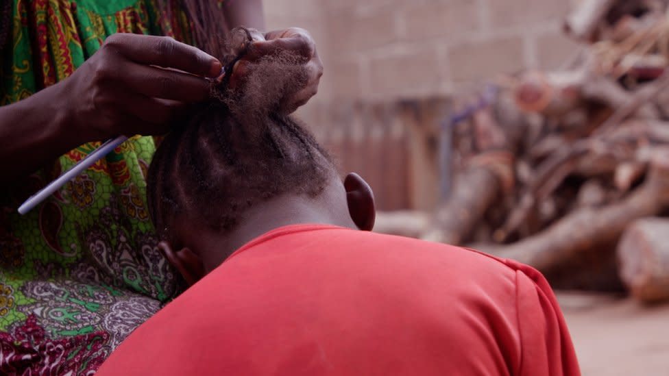 Young girl having her hair braided.