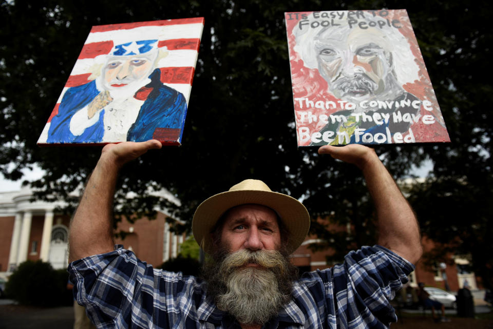 <p>Daniel Gray, an artist from Crozet, Virginia, holds his paintings before “Charlottesville to D.C: The March to Confront White Supremacy,” a ten-day trek to the nation’s capital from Charlottesville, Va., Aug. 28, 2017. (Photo: Sait Serkan Gurbuz/Reuters) </p>