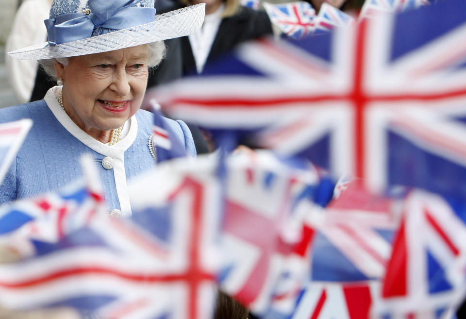 FILE - In this Tuesday, June 21, 2011 file photo, schoolchildren wave Union flags as Britain's Queen Elizabeth II leaves St Paul's Cathedral in London after attending a service to celebrate its Tercentenary. Queen Elizabeth II, Britain’s longest-reigning monarch and a rock of stability across much of a turbulent century, has died. She was 96. Buckingham Palace made the announcement in a statement on Thursday Sept. 8, 2022. (AP Photo/Akira Suemori, Pool, File)