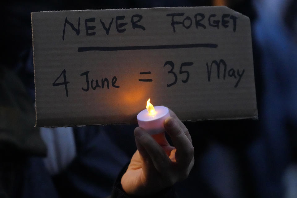 A protester holds a placard and an LED candle during a Candlelight vigil to commemorate the 35th anniversary of the 1989 pro-democracy movement and China's Tiananmen Square crackdown approaches at the Chinese embassy in London, Tuesday, June 4, 2024.(AP Photo/Kirsty Wigglesworth)