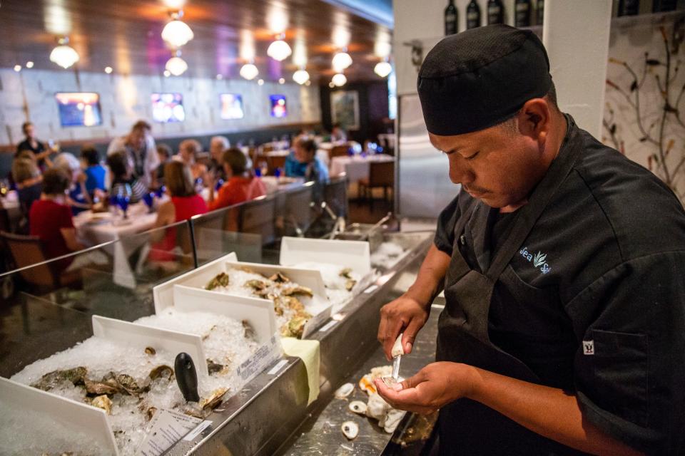 Ruben Ramos shucks oysters for dinner guests at Sea Salt in downtown Naples on Thursday, August 2, 2018. 