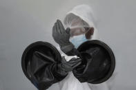 FILE - In this July 17, 2020, file photo, a health care worker sanitizes her equipment while working at a walk-up COVID-19 testing site during the coronavirus pandemic in Miami Beach, Fla. As the world races to find a vaccine and a cure for COVID-19, there is seemingly no antidote in sight to the burgeoning outbreak of coronavirus conspiracy theories, hoaxes, anti-mask myths and sham treatments. (AP Photo/Lynne Sladky, File)