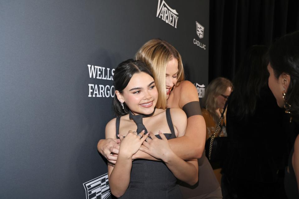 Ariana Greenblatt and Margot Robbie share a hug on the red carpet.