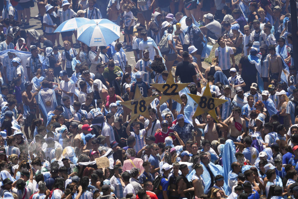 Argentine soccer fans holding signs with the years their team won previous World Cup tournaments gather at the Obelisk monument for a homecoming parade after the team won another World Cup title in Buenos Aires, Argentina, Tuesday, Dec. 20, 2022. (AP Photo/Matilde Campodonico)