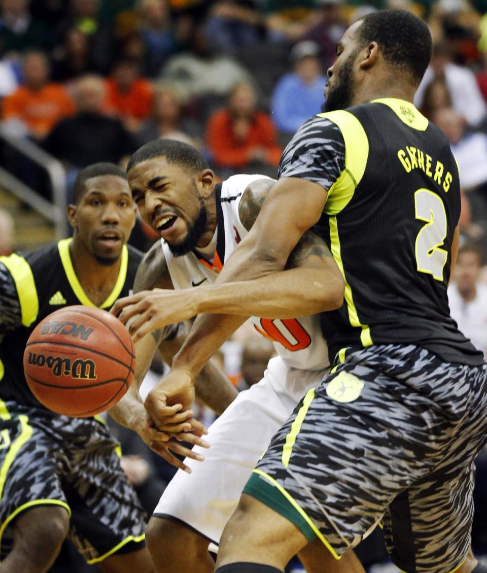 FILE - This March 14, 2013 file photo shows Oklahoma State forward Michael Cobbins (20) as he is fouled by Baylor forward Rico Gathers (2) during the second half of an NCAA college basketball game in the Big 12 tournament in Kansas City, Mo. Oklahoma State won 74-72. The neon-colored jerseys and camouflage-covered shorts debuted by six teams in their post-season conference championships ahead of the NCAA men's basketball tournament weren't well received in the press and social media. The changes happened to be in line with fashion runways and in recreational athleticwear, where highlighter brights and creative camo have been bona fide trends, and alternate uniforms have become part of the college football and basketball landscape, but on the court, these uniforms still made fans cringe. (AP Photo/Orlin Wagner, file)