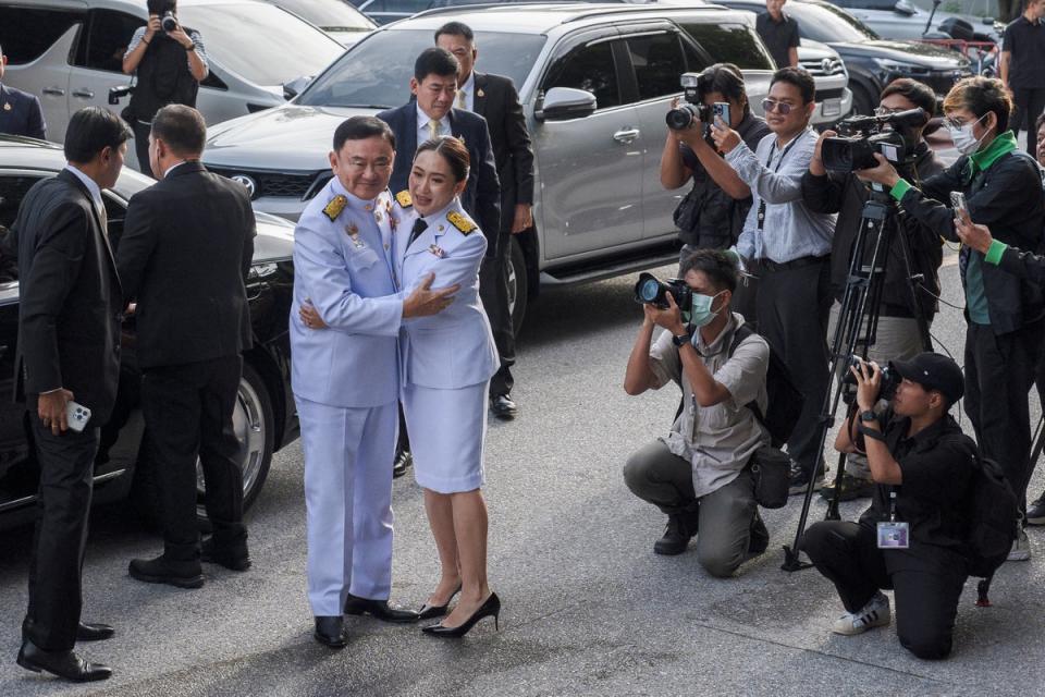 Patongtarn Shinawatra abbraccia suo padre, l'ex primo ministro Thaksin Shinawatra, mentre arrivano per la cerimonia di approvazione reale (AFP tramite Getty Images)