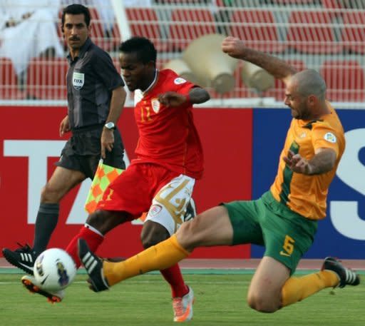 Oman's Saad Suhail (C) fights for the ball with Australia's Sasa Ognenovski (R) during their group B 2014 World Cup Asian qualifying football match in Muscat. The match ended in a 0-0 draw