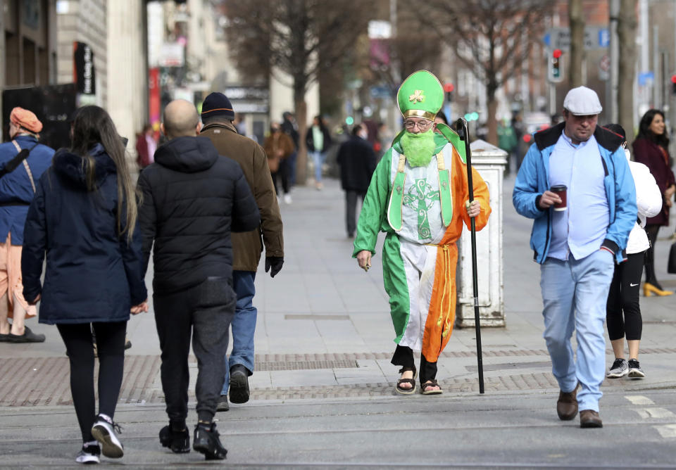 A man dressed as St Patrick walks down O'Connell street in Dublin, Ireland, Wednesday, March, 17, 2021. The St Patrick's Day parades across Ireland were canceled for the second year due to COVID-19 pandemic. (AP Photo/Peter Morrison)