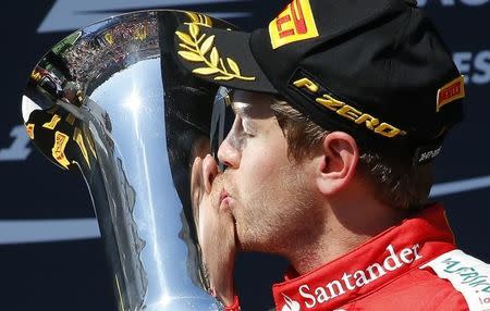 Winner Ferrari Formula One driver Sebastian Vettel of Germany kisses the trophy after the Hungarian F1 Grand Prix at the Hungaroring circuit, near Budapest, Hungary July 26, 2015. REUTERS/Laszlo Balogh