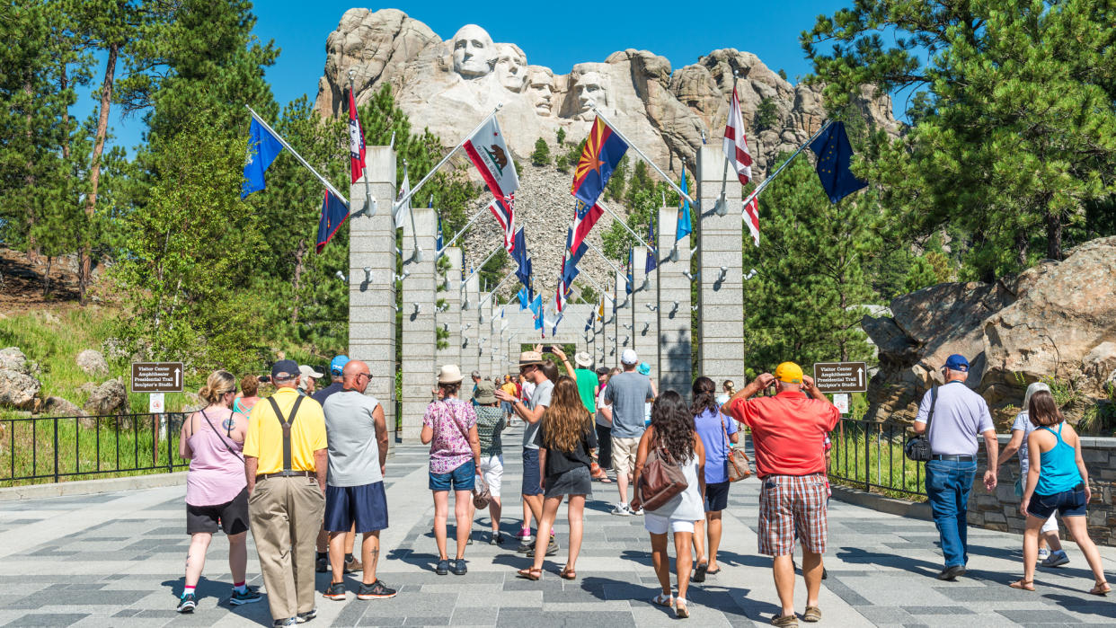 The Entrance of the Mount Rushmore National Monument on a sunny summer day with tourists and taking photographs of the view, Black Hills National Forest, South Dakota, USA.