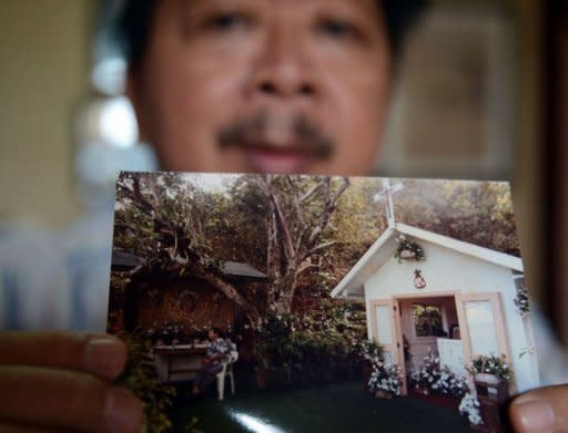 Filipino mortician Frank Malabed holds a photo of him sitting next to the mausoleum of the late Philippines dictator Ferdinand Marcos in Hawaii. Malabed's most famous client was Marcos, the dictator whose two-decade rule of the country ended in 1986