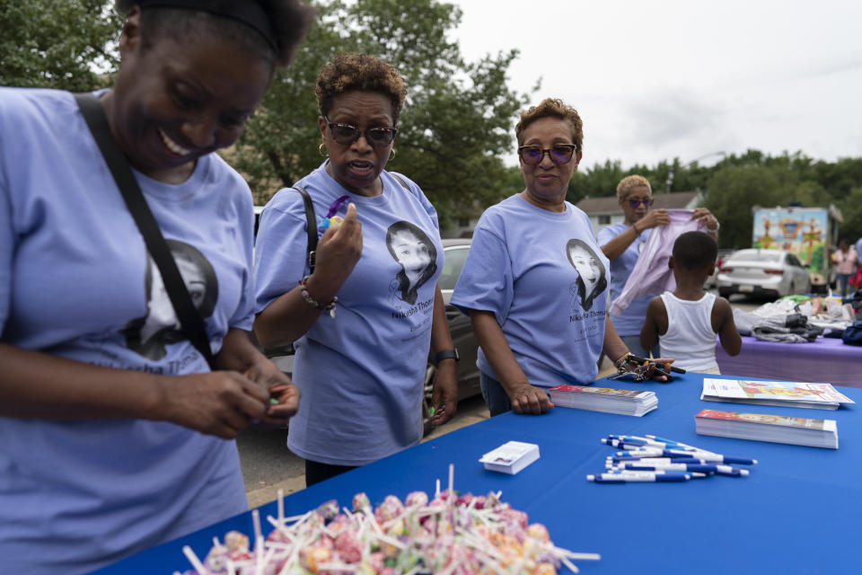 Nikiesha Thomas family members from left, Veronica McLeod, cousin, Sheron Mundle-Kong, aunt, Venice Mundle-Harvey, aunt, and Nadine Thomas, mother, wear T-shirts with Nikiesha's image during a Back To School Block Party in the Robinwood Community of Annapolis, Md., Sunday, Aug. 21, 2022. Nikiesha Thomas was shot and killed by her ex-boyfriend just days after filing for a protective order. Victims of abuse and their families saw a quiet breakthrough this summer when the passage of a bipartisan gun safety bill in Congress included a proposal that would make it more difficult for intimate partners of convicted domestic abusers to obtain firearms. (AP Photo/Carolyn Kaster)