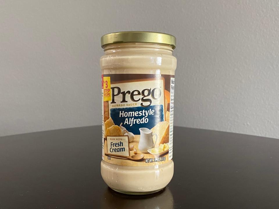 Jar of Prego Alfredo sauce on a black table