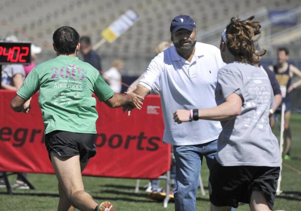 Penn State and Pittsburgh Steelers legend Franco Harris high-fives runners as they approach the finish line of the Paterno Family Beaver Stadium Run in 2016.