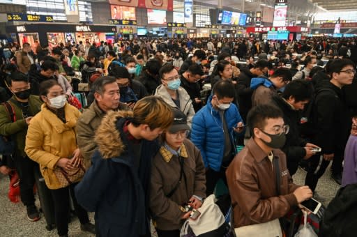 At Shanghai's Hongqiao Railway Station some travellers wait to board their trains wearing face masks