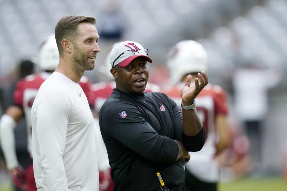 Arizona Cardinals head coach Kliff Kingsbury, left, talks with defensive coordinator Vance Joseph, right, during NFL football training camp practice, Monday, Aug. 2, 2021, in Glendale, Ariz. (AP Photo/Ross D. Franklin)