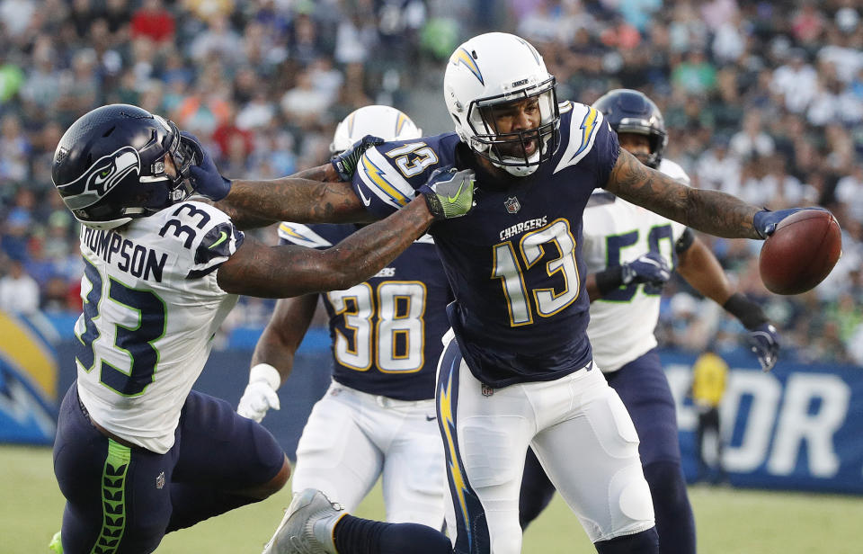 Los Angeles Chargers wide receiver Keenan Allen (13) stiff-arms Seattle Seahawks defensive back Tedric Thompson (33) during the first half of an NFL preseason football game Saturday, Aug. 18, 2018, in Carson, Calif. (AP Photo/Jae C. Hong)