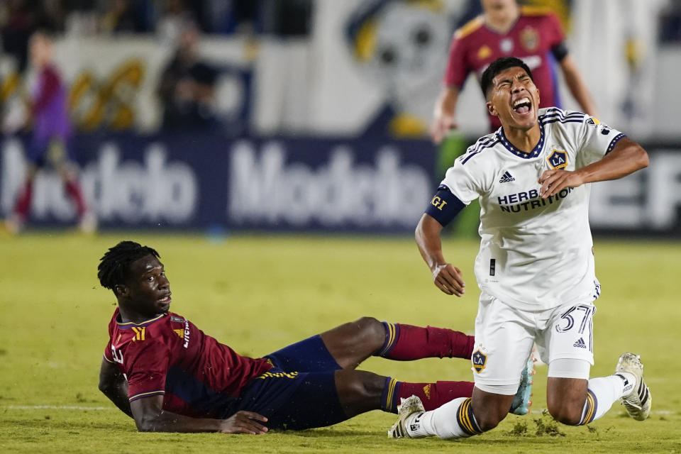 LA Galaxy midfielder Daniel Aguirre, right, reacts after being slide-tackled by Real Salt Lake midfielder Emeka Eneli during the second half of an MLS soccer match Saturday, Oct. 14, 2023, in Carson, Calif. (AP Photo/Ryan Sun)