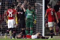 Referee Michael Oliver signals on the medics as Manchester United's Nemanja Vidic lays injured during their English Premier League soccer match against Arsenal at Old Trafford in Manchester, northern England, November 10, 2013.