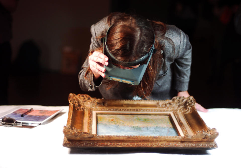 This Oct. 10, 2012 photo shows Denver Art Museum associate registrar Laura Paulick Moody inspecting the condition of Vincent Van Gogh’s “Edge of a Wheat Field with Poppies” before it is hung on the museum wall in Denver. The museum is in the middle of installing more than 70 loaned works for its upcoming 12-week “Becoming Van Gogh” exhibit, which explores how the self-taught painter developed his signature style. The exhibit runs Oct. 21-Jan. 20. (AP Photo/Thomas Peipert)