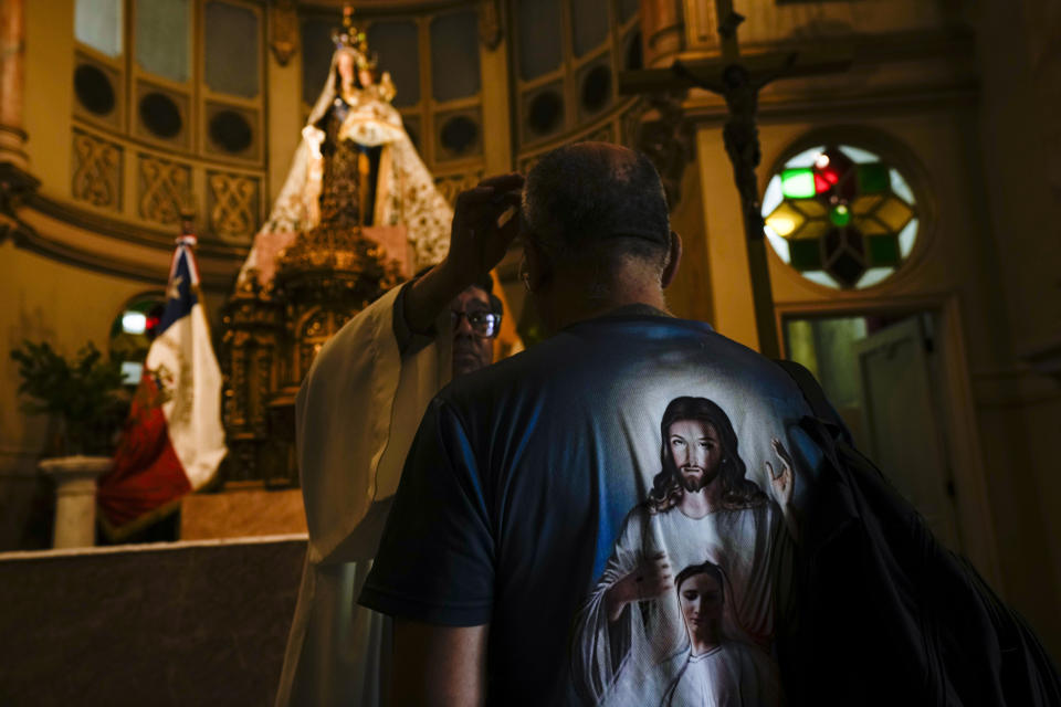 A priest marks a person's forehead with a cross of ashes during Ash Wednesday Mass at the Cathedral in Santiago, Chile, Wednesday, Feb. 14, 2024. Ash Wednesday marks the start of the Lenten season for Catholics. (AP Photo/Esteban Felix)