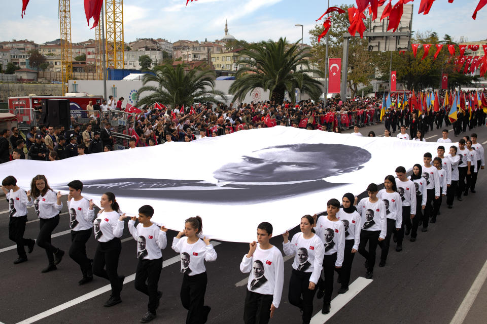 Participantes sostienen una imagen gigante de Mustafá Kemal Atatürk --el fundador de la República de Turquía-- como parte de los festejos por el centenario de la creación de la república moderna y secular, el domingo 29 de octubre de 2023, en Estambul. (AP Foto/Emrah Gurel)