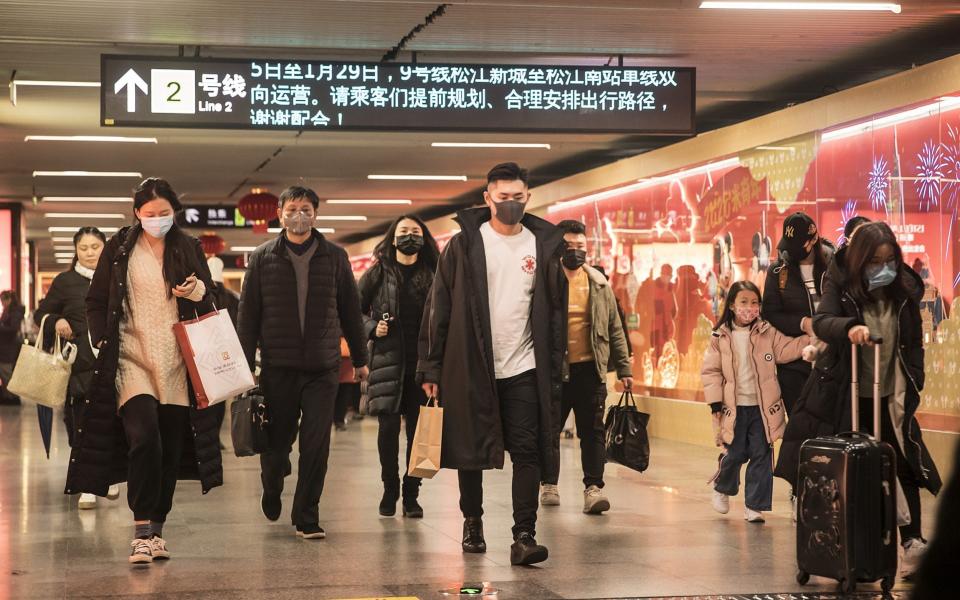 Commuters wearing protective masks walk through a subway station ahead of the Lunar New Year in Shanghai - Bloomberg