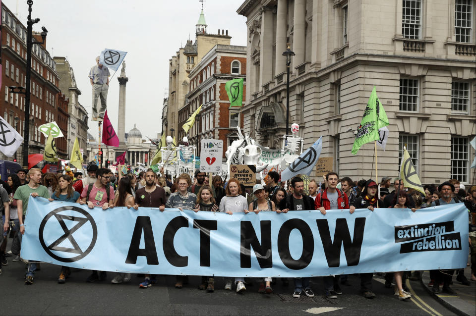 FILE - In this Tuesday April 23, 2019 file photo, climate change protesters march along Whitehall toward parliament, in London. Britain's prime minister has announced plans to eliminate the country's net contribution to climate change by 2050. Theresa May said the plan will be put before Parliament Wednesday, June 12. She says the amendment to the 2008 Climate Change Act will intensify Britain's push to drastically reduce carbon emissions because "standing by is not an option." (AP Photo/Matt Dunham, file)