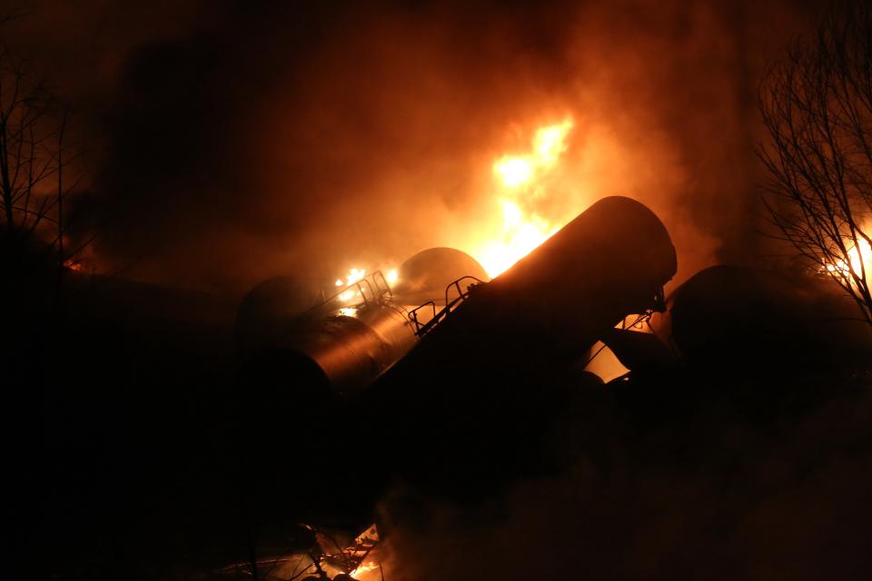 FILE - In this Feb. 16, 2015 file photo, a derailed oil tanker train cars burn near Mount Carbon, W.Va. The Trump administration vastly understated the potential benefits of installing more advanced brakes on trains that haul explosive fuels when it cancelled a requirement for railroads to begin using the equipment. A government analysis used by the administration to justify the cancellation omitted up to $117 million in potential reduced damages from using electronic brakes. Department of Transportation officials acknowledged the error after it was discovered by The Associated Press during a review of federal documents but said it would not have changed their decision. (Marcus Constantino/The Daily Mail via AP, File)