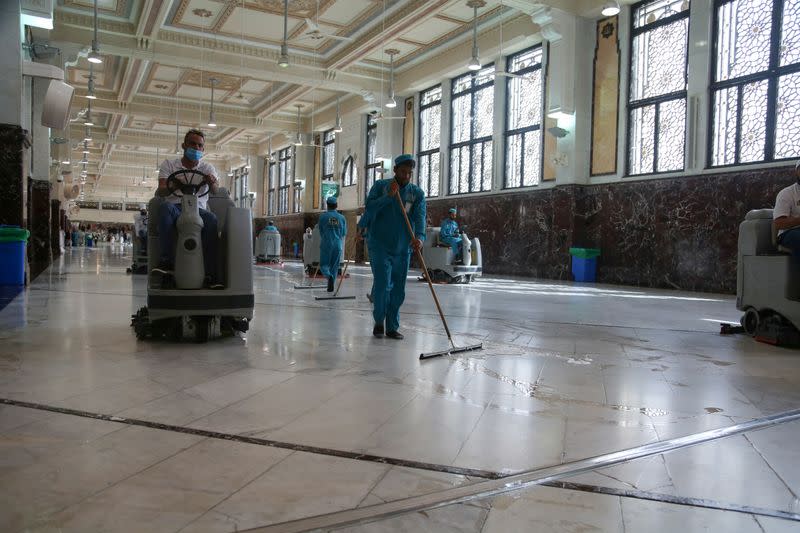 Cleaners wear protective face masks, following the outbreak of the coronavirus, as they swipe the floor at the Grand mosque in the holy city of Mecca