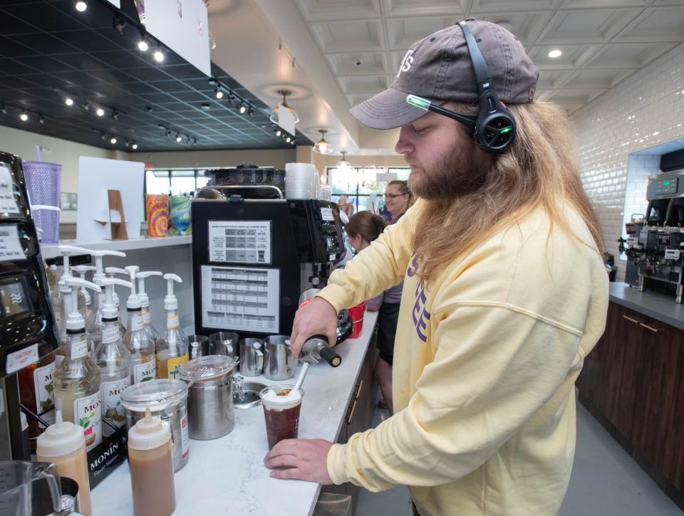 General manager Ryan Perrilloux tops a Southern Pecan Cold Brew with sweet cold foam at PJ's Coffee of New Orleans at 85 West Airport Boulevard in Pensacola on Thursday, Aug. 24, 2023.