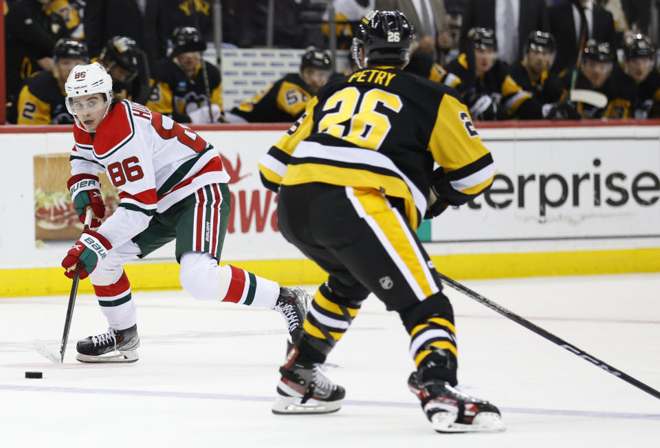 New Jersey Devils center Jack Hughes (86) plays the puck against Pittsburgh Penguins defenseman Jeff Petry (26) during the second period of an NHL hockey game Tuesday, April 4, 2023, in Newark, N.J. (AP Photo/Noah K. Murray)