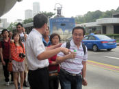 Transport Minister Lui Tuck Yew speaks to affected commuters outside Dhoby Ghaut station to obtain their feedback on the situation and their waiting times. (Yahoo! photo/Jeanette Tan)