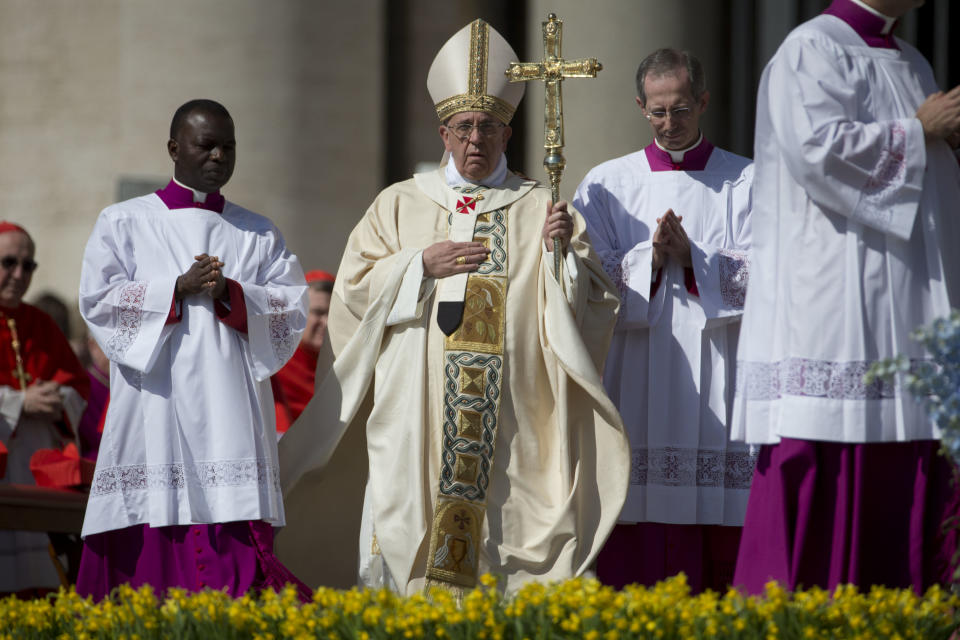 El papa Francisco (centro) llega para celebrar la misa de Pascua en la Plaza de San Pedro en el Vaticano el domingo 20 de abril de 2014. (Foto AP/Andrew Medichini)