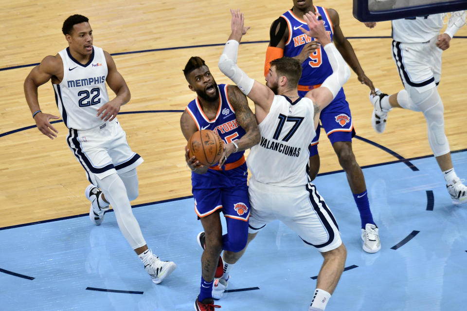 New York Knicks forward Reggie Bullock handles the ball against Memphis Grizzlies center Jonas Valanciunas (17) in the second half of an NBA basketball game Monday, May 3, 2021, in Memphis, Tenn. (AP Photo/Brandon Dill)